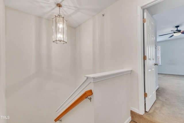 interior space featuring ceiling fan with notable chandelier and light colored carpet