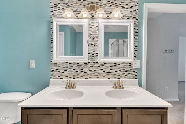 bathroom with vanity, tasteful backsplash, and toilet