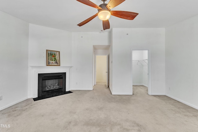 unfurnished living room with light carpet and ceiling fan