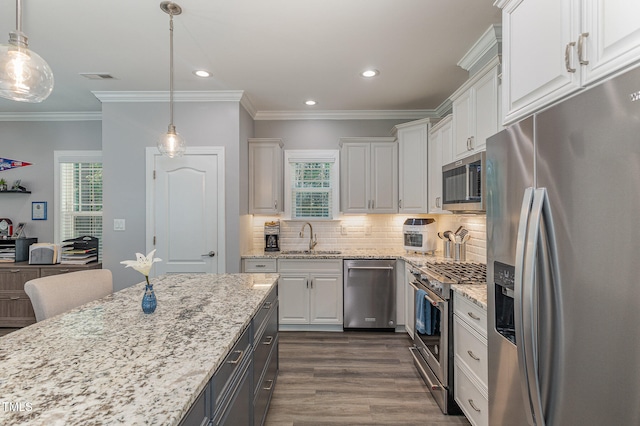 kitchen with stainless steel appliances, hanging light fixtures, sink, and white cabinetry