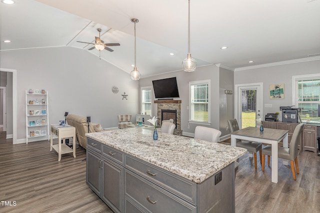 kitchen with ceiling fan, lofted ceiling, a fireplace, and a wealth of natural light