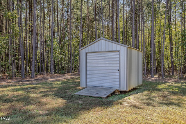 view of outdoor structure featuring a lawn and a garage