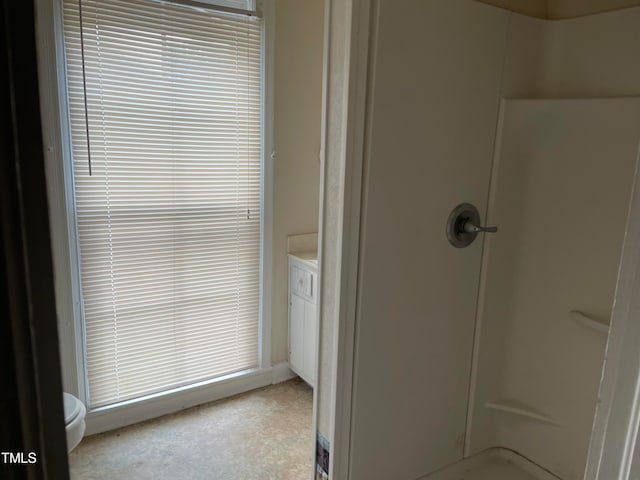 bathroom featuring a shower, vanity, and toilet