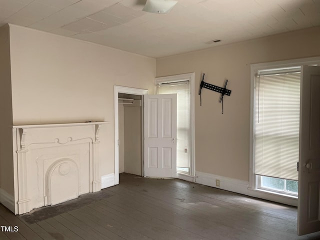 unfurnished bedroom with a closet and dark hardwood / wood-style floors