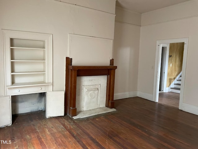 unfurnished living room with built in features and dark hardwood / wood-style floors