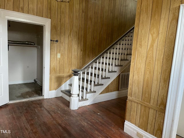 staircase featuring wood walls and hardwood / wood-style floors