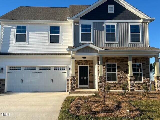 craftsman-style house with a garage, concrete driveway, and a porch