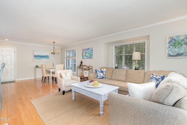 living room featuring ornamental molding, light hardwood / wood-style floors, and a notable chandelier