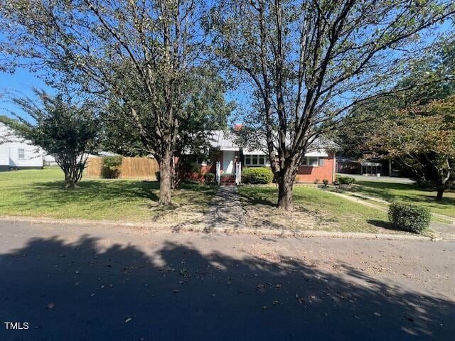 view of front facade with a front lawn and fence