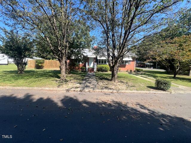 view of front facade featuring a front yard and fence