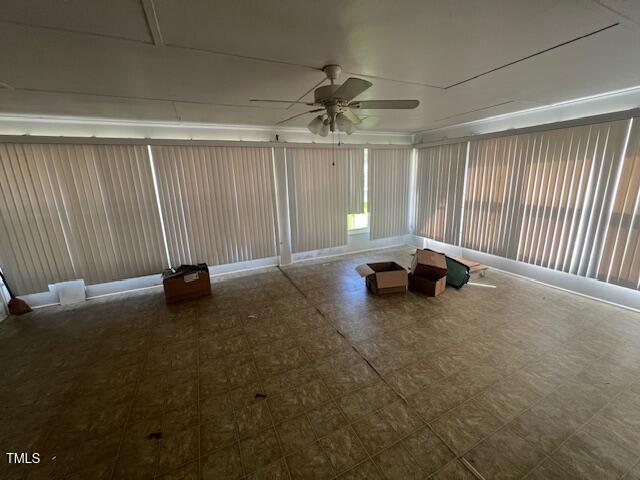 unfurnished sunroom featuring a ceiling fan