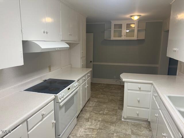 kitchen featuring light countertops, under cabinet range hood, white cabinetry, and electric range