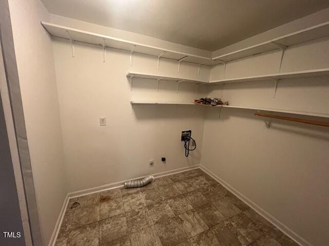 laundry room with laundry area, hookup for an electric dryer, and baseboards