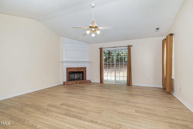 unfurnished living room with light wood-type flooring, a textured ceiling, a brick fireplace, ceiling fan, and vaulted ceiling