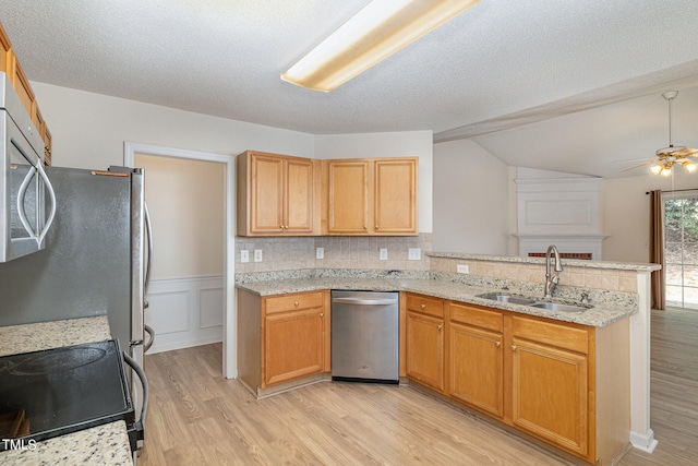 kitchen with kitchen peninsula, tasteful backsplash, appliances with stainless steel finishes, light wood-type flooring, and sink