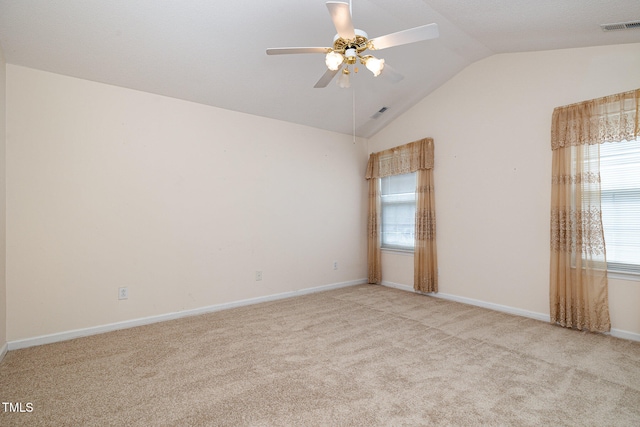 spare room featuring vaulted ceiling, light colored carpet, and ceiling fan