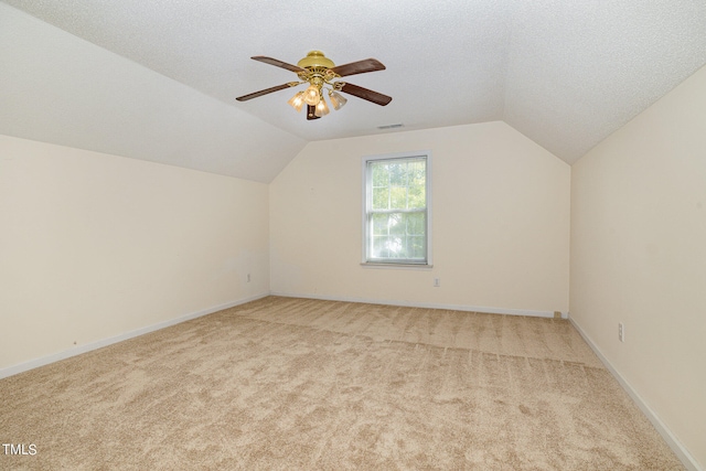 bonus room featuring a textured ceiling, lofted ceiling, and light colored carpet