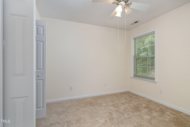 spare room with light carpet, a textured ceiling, and ceiling fan