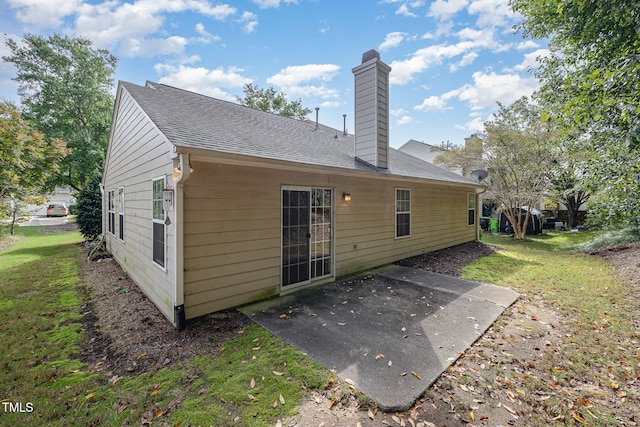 back of property with a yard and a patio