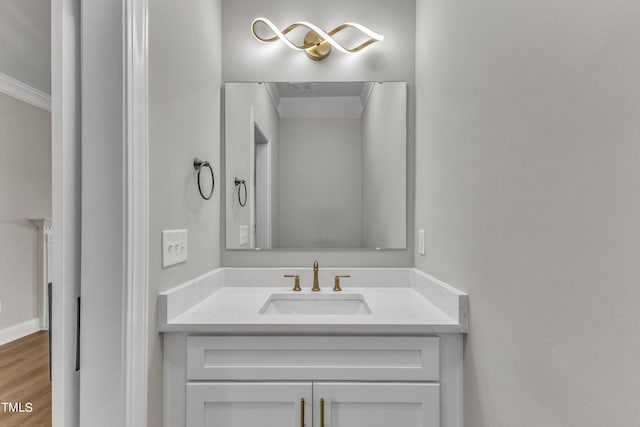 bathroom with ornamental molding, wood-type flooring, and vanity