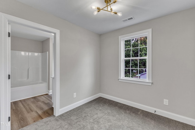 unfurnished room featuring light hardwood / wood-style floors and a chandelier