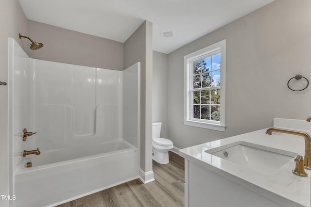 full bathroom with wood-type flooring, shower / bathtub combination, vanity, and toilet