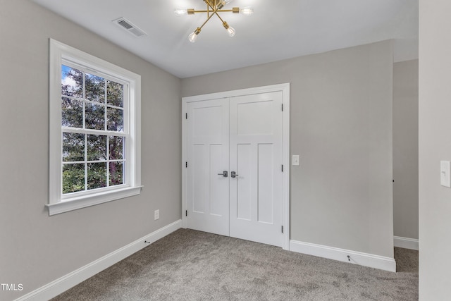 unfurnished bedroom featuring multiple windows, light carpet, and a closet