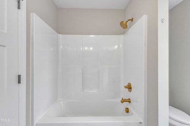 bathroom featuring shower / bathing tub combination and toilet