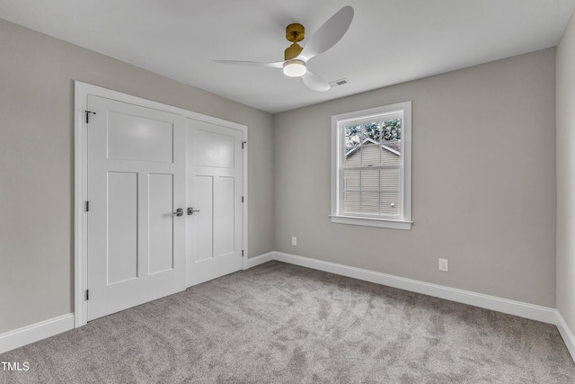 unfurnished bedroom featuring light carpet, a closet, and ceiling fan