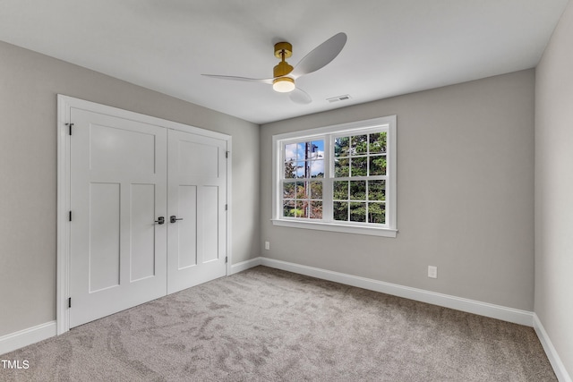 unfurnished bedroom with a closet, ceiling fan, and carpet flooring