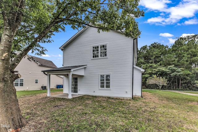 back of property with cooling unit, a yard, and a patio area