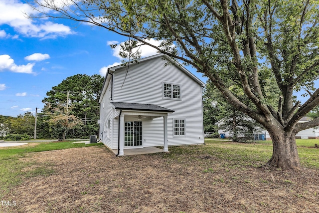 back of house with cooling unit, a lawn, and a patio area