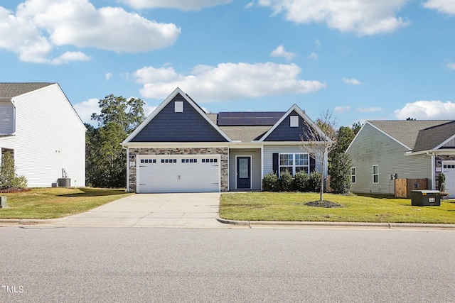 craftsman house with solar panels, an attached garage, central AC, driveway, and a front lawn