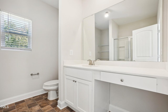 full bathroom with toilet, vanity, a stall shower, baseboards, and stone finish floor