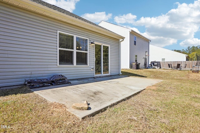 rear view of property featuring a yard, fence, and a patio