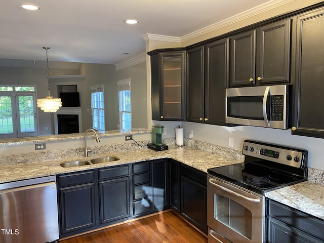 kitchen with stainless steel appliances, a wealth of natural light, sink, and ornamental molding