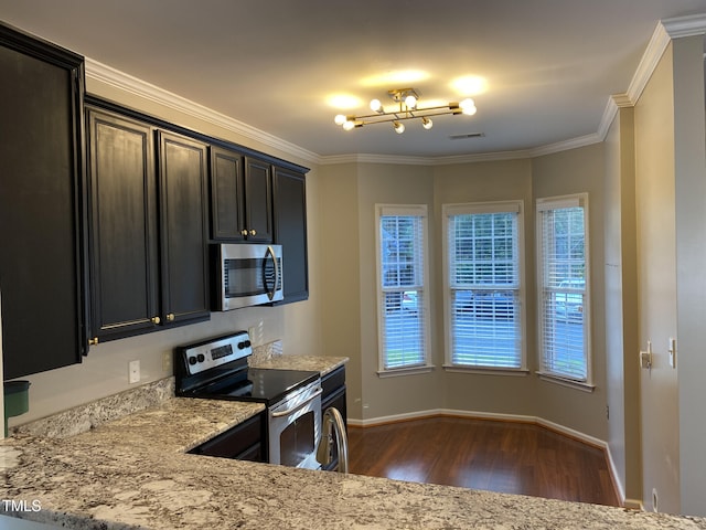 kitchen with stainless steel appliances, dark hardwood / wood-style floors, light stone counters, and ornamental molding