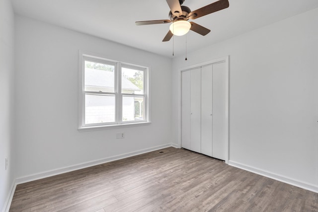 unfurnished bedroom with ceiling fan, a closet, and light hardwood / wood-style floors