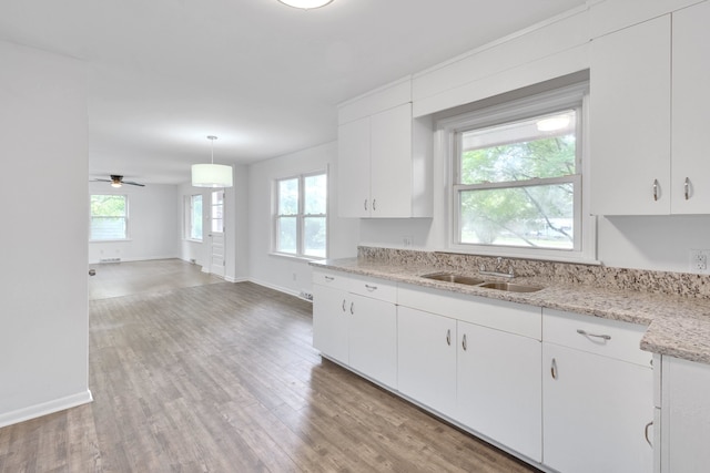 kitchen featuring light wood-type flooring, white cabinetry, ceiling fan, and hanging light fixtures