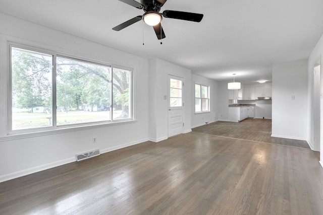 unfurnished living room with ceiling fan and dark hardwood / wood-style flooring