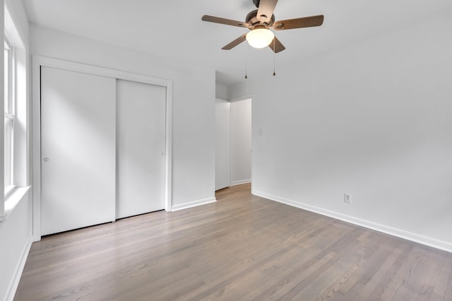 unfurnished bedroom featuring light hardwood / wood-style flooring, a closet, and ceiling fan