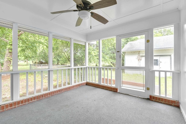 unfurnished sunroom featuring ceiling fan and a wealth of natural light