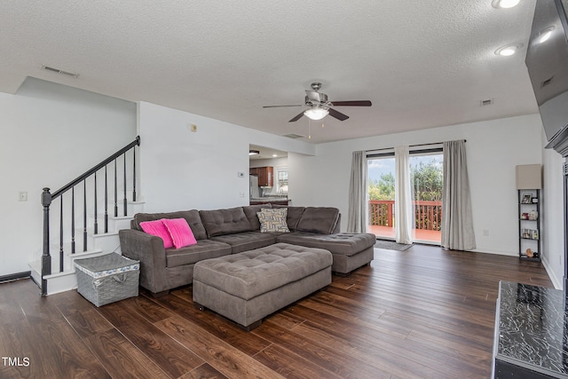 living room with ceiling fan, dark hardwood / wood-style floors, and a textured ceiling