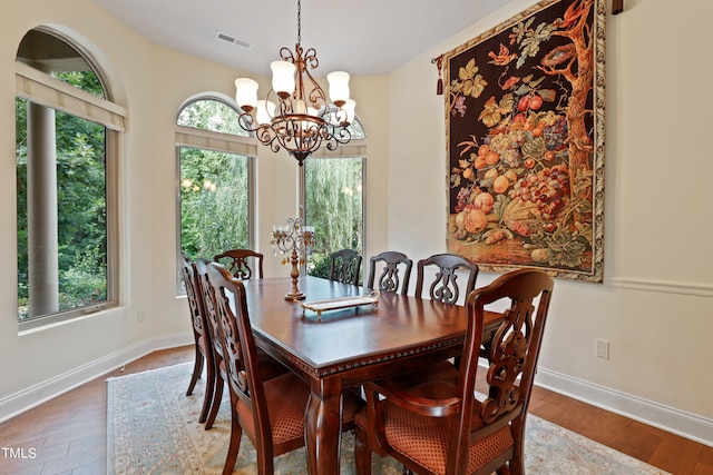 dining area with an inviting chandelier, plenty of natural light, and hardwood / wood-style floors