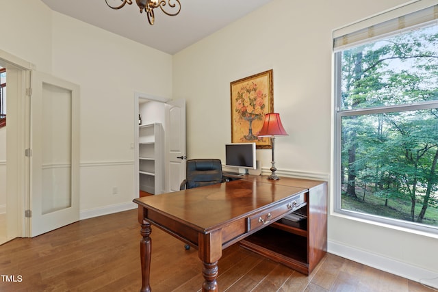 office area with an inviting chandelier, a wealth of natural light, and light hardwood / wood-style floors