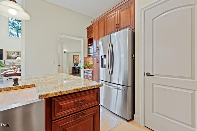 kitchen featuring light stone counters, stainless steel appliances, light tile patterned floors, and tasteful backsplash