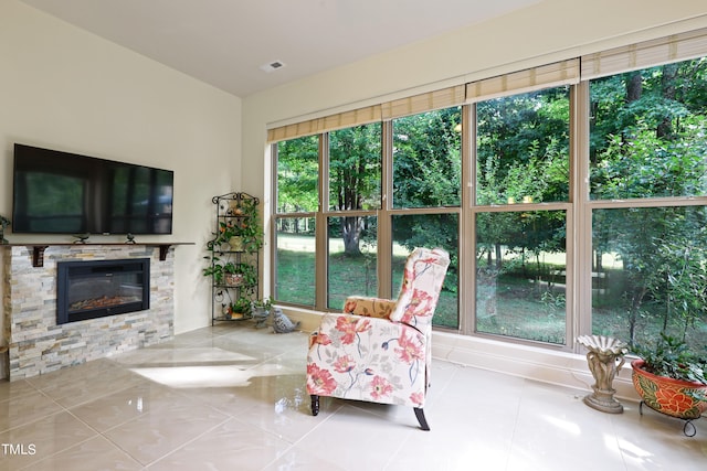 sunroom / solarium with a stone fireplace