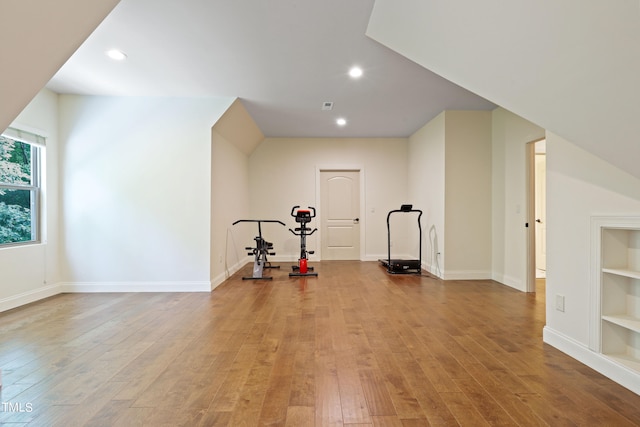 workout room with built in shelves and light hardwood / wood-style floors