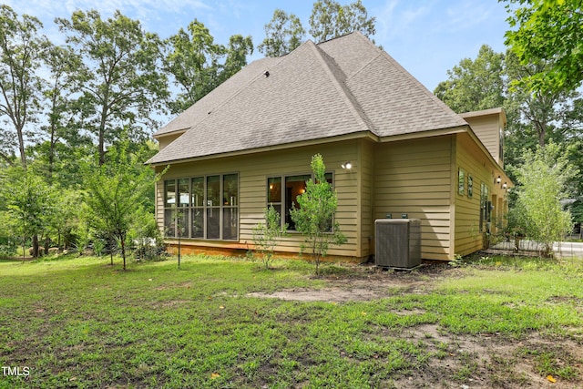 back of property with cooling unit and a yard