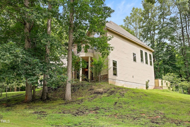 view of property exterior featuring a balcony and a yard